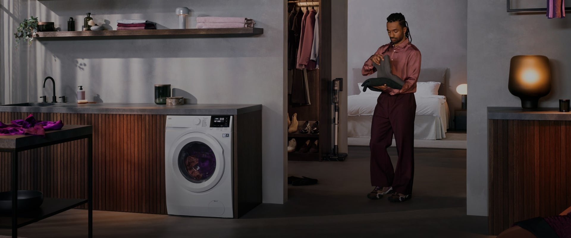 Henkilö seisoo pyykinpesukoneen vieressä.